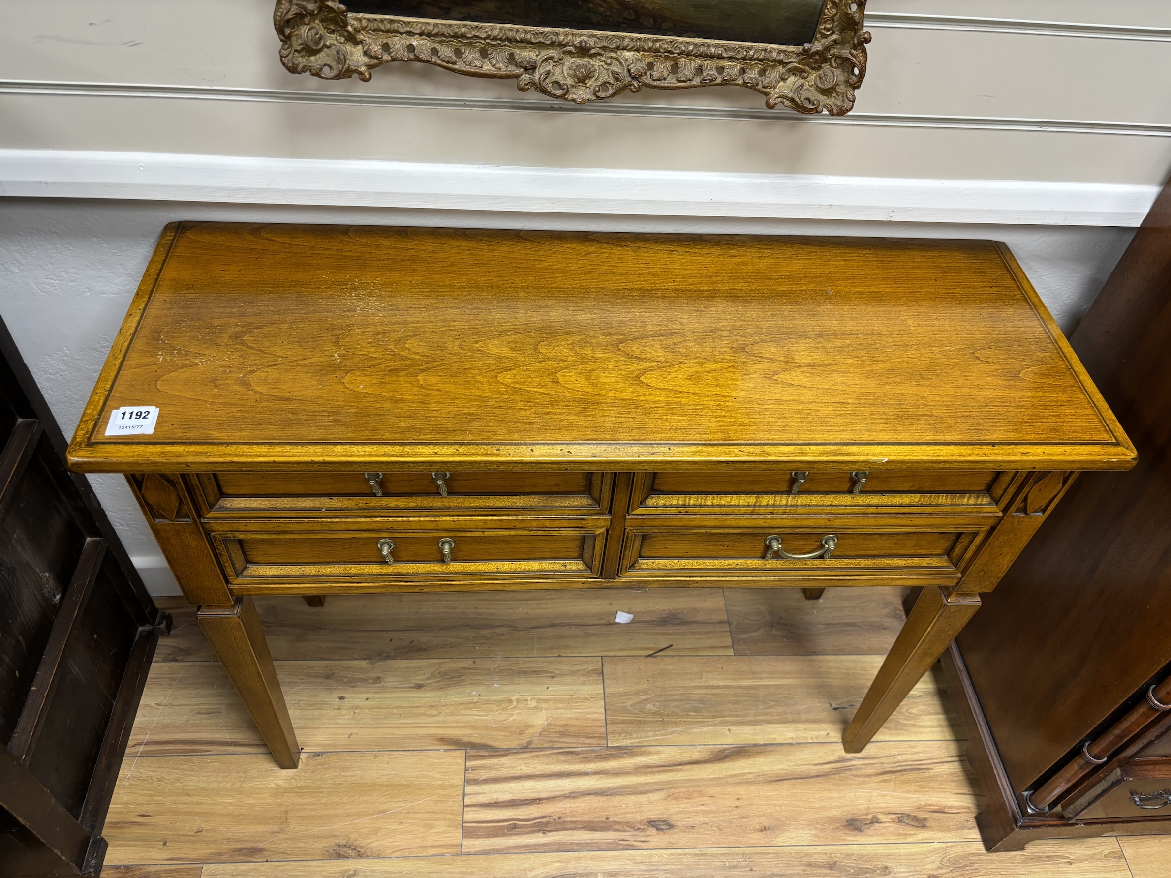 A reproduction walnut four drawer side table, width 101cm, depth 36cm, height 77cm